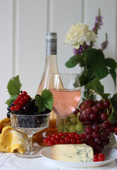 Still life with wine and grapes. Colorful photo of bottle of rose wine and different sorts of...