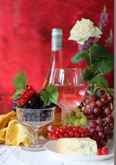 Still life with wine and grapes. Colorful photo of bottle of rose wine and different sorts of...