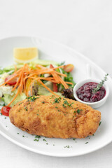 chicken cordon bleu with salad and cranberry sauce