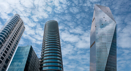 Modern tower buildings or skyscrapers in financial district with cloud on sunny day. bottom view