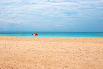 Sea beach and sandy shore with sun umbrella. Rest and relaxation on holiday at the resort