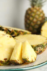 Plate with tasty cut pineapple on table, closeup