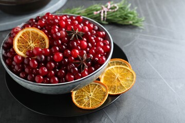 Fresh ripe cranberries, spices and orange slices on grey table