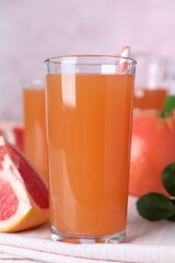 Tasty freshly made grapefruit juice on towel, closeup