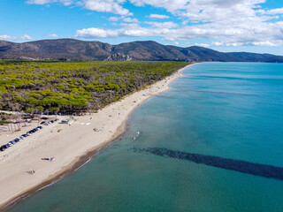 Aerial view of Alberese's beach during a sunny summer day with white clouds (in a southerly direction). Sea, beach and mountains in Alberese, Maremma National Park in the beautiful Tuscany territory.