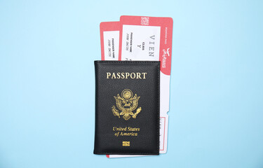 United States passport with tickets on light blue background, top view