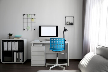 Comfortable blue chair near desk in stylish office interior