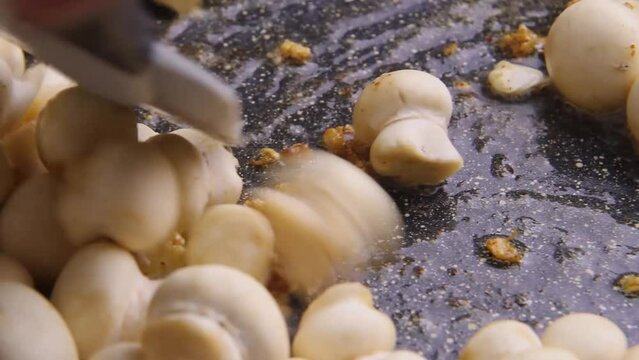 Champignon mushrooms in a pan fried in butter with garlic.