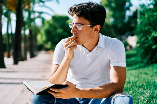 Pensive student with notebook thinking about project