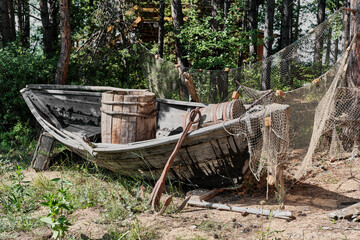 Old fishing wooden longboat and fishing nets in rural area near lake Baikal, Buryatia, Russia.