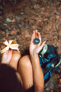 Person sitting and navigating with compass in his hands