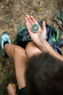 Person sitting and navigating with compass in his hands