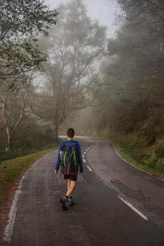 Tourist with backpack walking up on hill