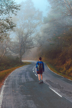Tourist with backpack walking up on hill