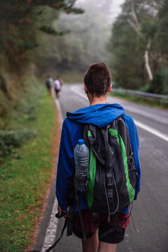 Tourist with backpack walking up on hill