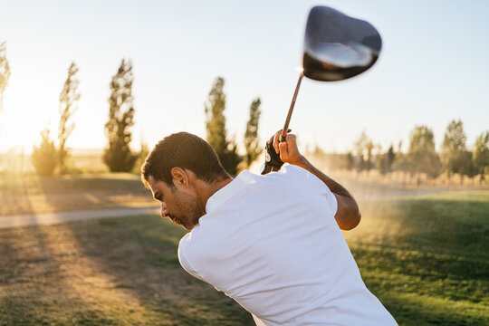 Golfer playing golf on course in countryside