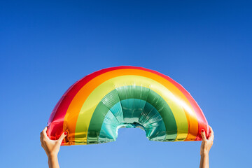 Anonymous person with inflatable rainbow