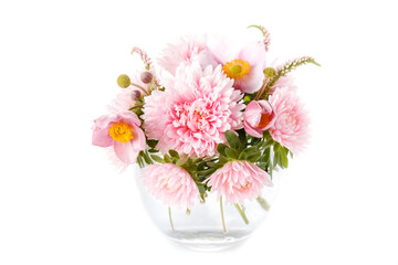 Graceful autumn bouquet of pink aster flowers, anemones in round glass vase isolated on white background