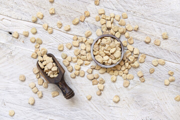 Bowl of raw dry Grass pea on wooden table top view. Legumes known in Italy as Cicerchia
