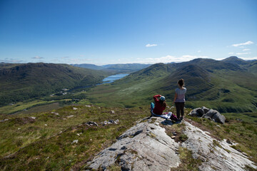 Fototapeta na wymiar femmes qui contemplent un magnifique paysage de montagne en Irlande. Beau point de vue sur un lac dans le Connemara. Une femme prend une photo