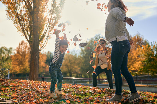 Carefree lesbian family with child playing in park