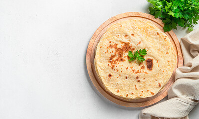 Indian flatbreads with fresh herbs on a gray background. Top view, copy space