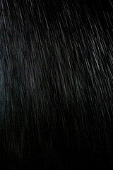 黒い背景に雨が降る