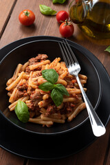Piatto di strozzapreti con ragu di carne, cibo italiano 