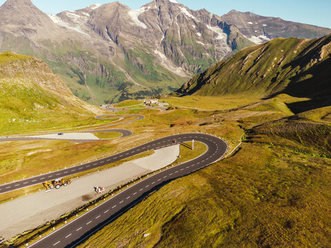 Bird's eye view of serpentine curves at sunny day. Aerial view of scenic route in Austria with name Grossglockner High Alpine Road. Some of hairpin turns of Hochtor Pass. 