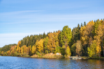 Cottage with a jetty by a lake at autumn