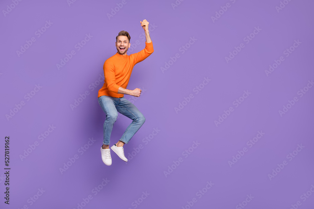 Sticker Full body photo of active energetic jumping man raise fists in victory fan support isolated on violet color background