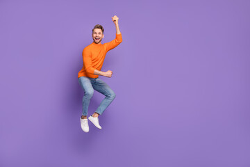 Fototapeta na wymiar Full body photo of active energetic jumping man raise fists in victory fan support isolated on violet color background