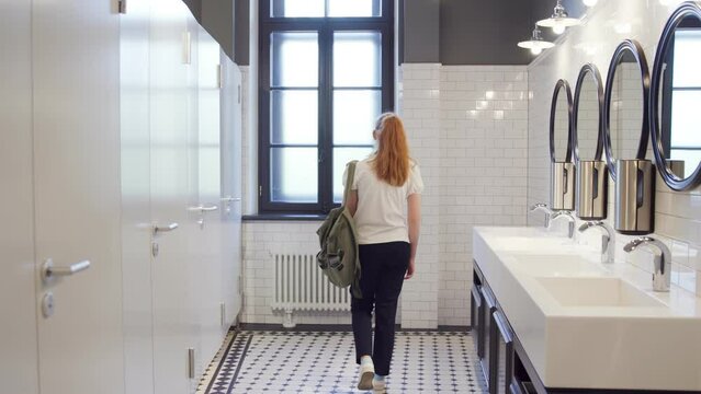 Sad and lonely teen girl sit on restroom floor alone