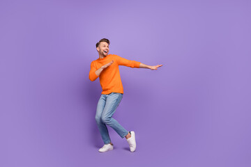 Fototapeta na wymiar Full body photo of attractive overjoyed man hear his favorite song start dancing isolated on violet color background