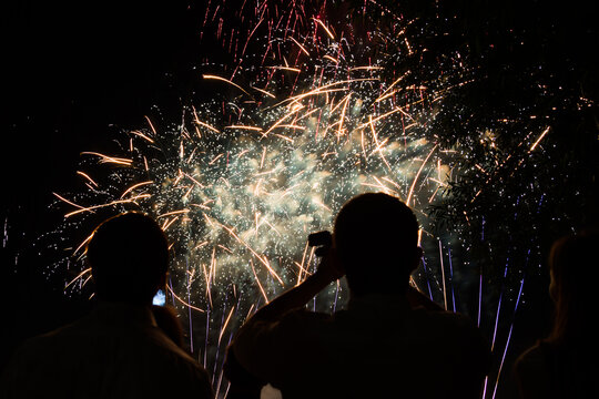 Black silhouette of people on the background of fireworks