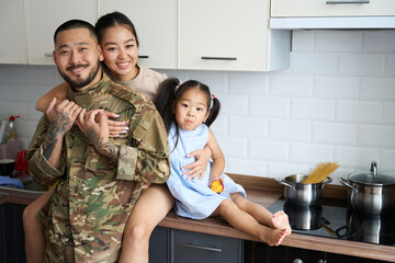 Woman hugging her military husband and little daughter - Powered by Adobe
