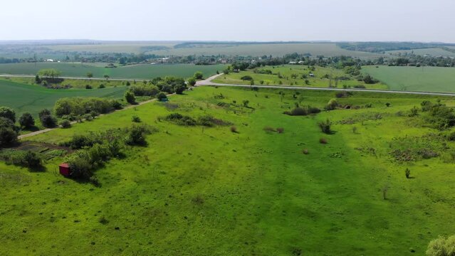 Aerial view. Rural road in the middle of green endless meadows. Sustainable meadow ecosystem. Ukraine