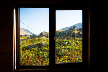 Window view to pristine georgian nature in caucasus mountains from shelter house on hiking trail