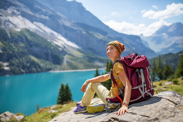 Fototapeta premium Tourist in the mountains in Switzerland on Lake Oeschinensee