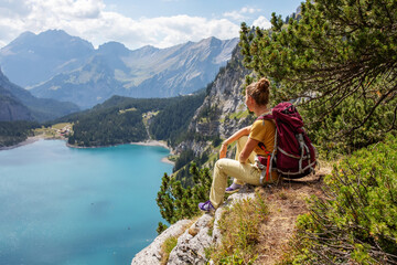 Naklejka na ściany i meble Tourist in the mountains in Switzerland on Lake Oeschinensee