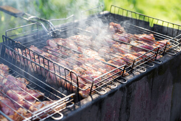 Fresh meat for barbecue, fried on fire. Selective focus. Grilled pork meat. Cooking barbecue on the grill with smoke. Picnic in nature.