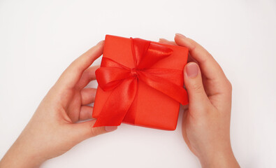  Female hands holding red gift box on white background.