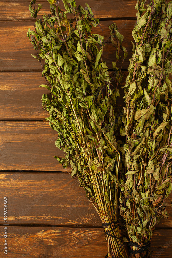 Sticker Dried mint leafs on wooden surface. Herbs and spices.