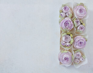 Zephyr bouquet of flowers in a gift box on a light background, top view