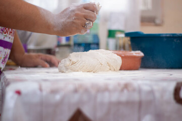 a woman kneading natural dough with white flour by hand