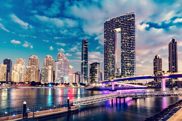 Dubai marina skyscrapers in UAE next to jumeirah beach at night.