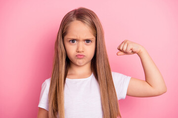 Photo of sportive little girl hand flexing demonstrating biceps isolated on pink color background