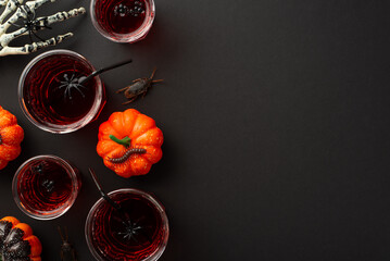 Halloween celebration concept. Top view photo of glasses with drink floating spiders skeleton hand...