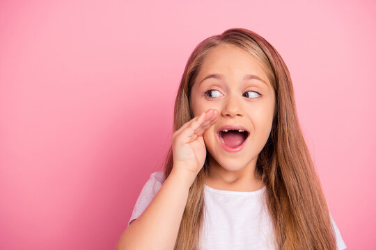 Photo of excited positive kid hand near mouth look empty space say tell news isolated on pink color background