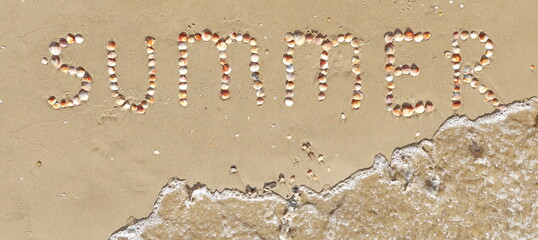Summer Background with Letters on the Sand. Inscription made of Shells.